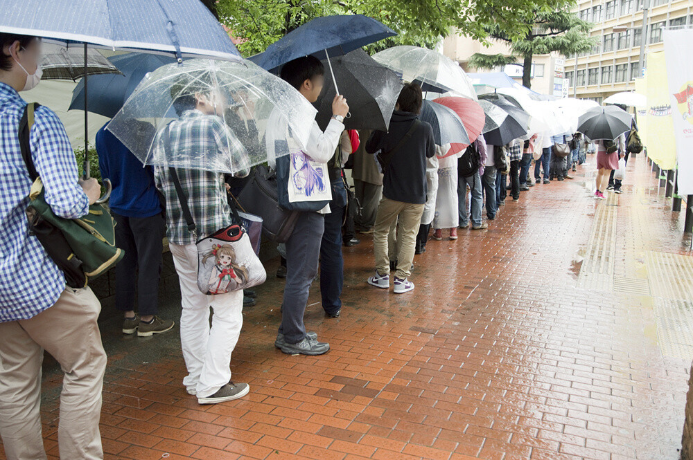 A line of people waiting to buy limited anime goods related to the Cinemachi Festival. 3