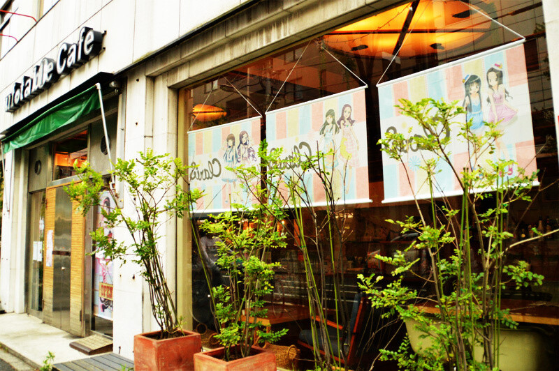 Ufotable Cafe’s exterior. At the entrance, large tapestries featuring ClariS are displayed. 0